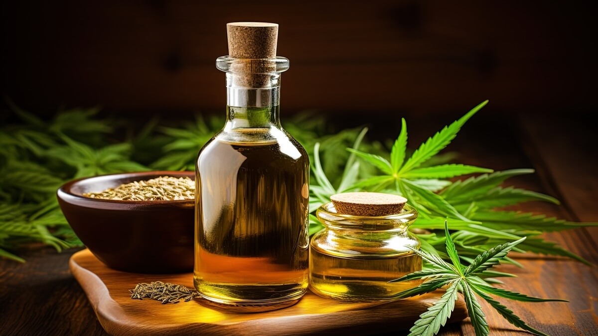 Prirodno CBD ulje za spavanje u staklenim bočicama s listovima konoplje na drvenom stolu